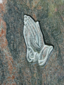 Nahaufnahme von einem Stein-Ornament das zwei Hände darstellt