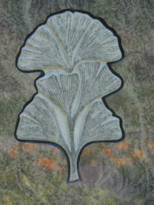 Nahaufnahme eines Baum-Ornaments am Grabstein