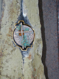 Nahaufnahme eines in einen Stein eingelassenen runden Ornaments, das ein Kreuz zeigt