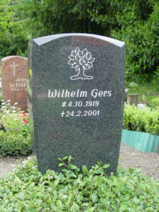 Polierter dunkler Grabstein mit Baum-Ornament