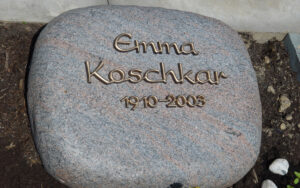 Einfacher Grabstein in Naturform mit Namenaufsatz aus Bronze