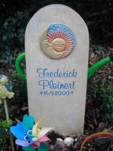 Grabstein eines Sternenkinds mit farbigen Sonne-Mond-Ornament