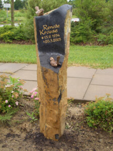 Hoher schmaler goldfarbener Naturstein mit zwei Bronzevögeln