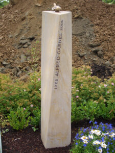 Grabsteinsäule aus Sandstein mit Bronzevogel