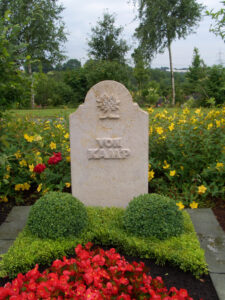 Sandstein-Grabstein mit Baum-Ornament auf einem Friedhof