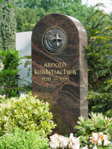 Brauner schmaler Grabstein eines Wahlgrabs mit Namensschriftzug und Ornament